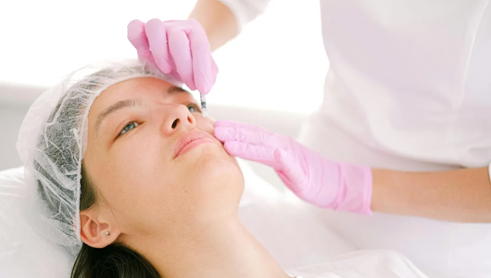 Cosmetologist menyuntikkan botox untuk perawatan anti aging di wajah wanita - Surabaya Skin Centre